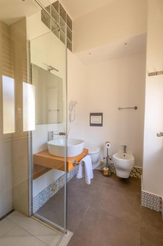 a bathroom with a glass shower and a sink at Athena Charming Rooms in Taormina