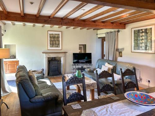 a living room with a couch and a fireplace at Ostlers End in Hartington