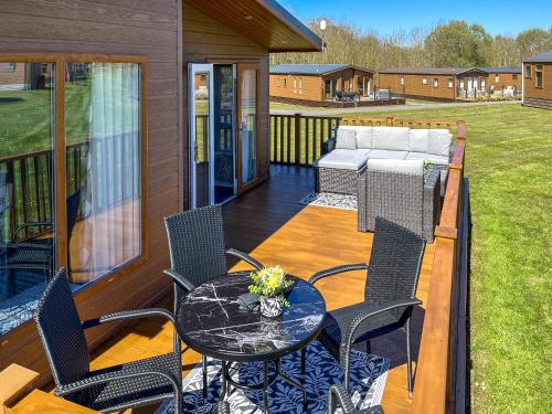 a patio with a table and chairs on a deck at The Valerie Jean in Bridlington