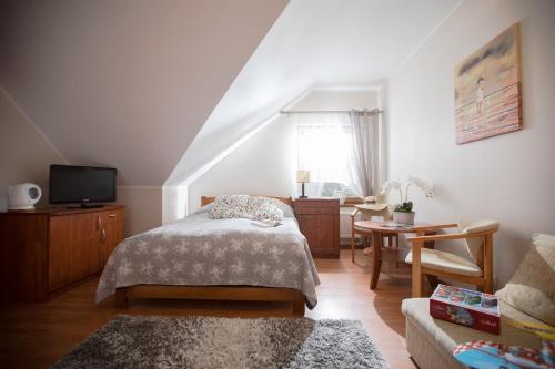 a bedroom with a bed and a living room at Domki i Pokoje -WISIENKA in Rewal