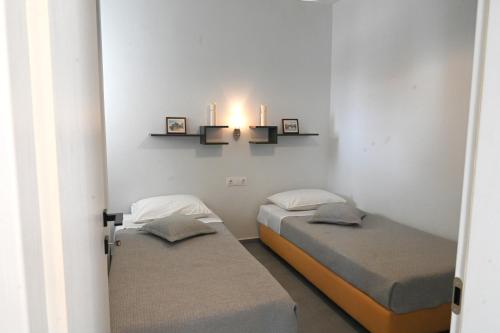 two beds in a room with two candles on the wall at Avra Port House in Porto Heli
