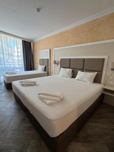 a bedroom with a large bed with two towels on it at Sun Boutique Pomorie in Pomorie