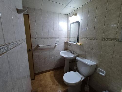 a bathroom with a toilet and a sink at Hotel cirse cr in Comodoro Rivadavia