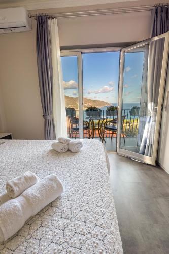 a bedroom with a bed and a view of the ocean at Athena Charming Rooms in Taormina