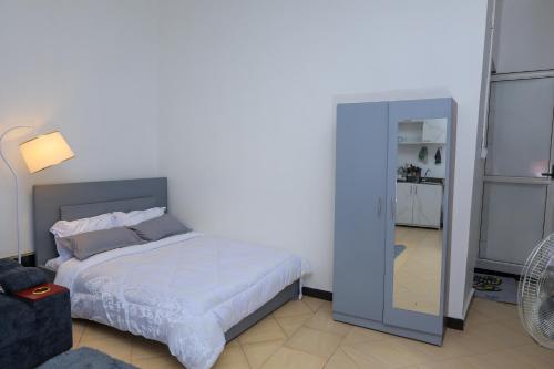 a bedroom with a bed and a mirror at The Comfort Den in Kampala