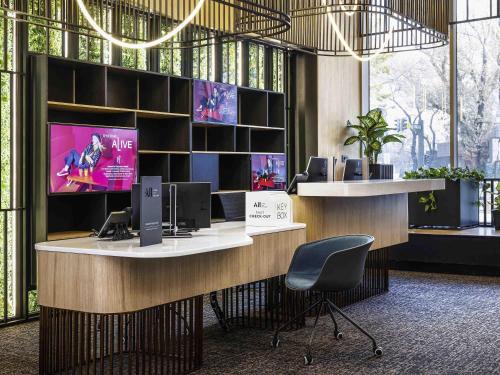 a lobby with a desk with two monitors and a chair at ibis Almaty Jetisu in Almaty