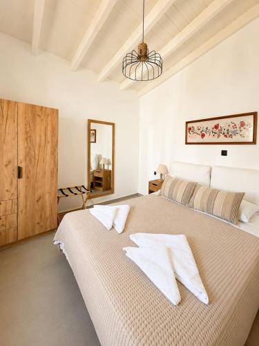 a white bedroom with a large bed and a mirror at Villa Elli in Halki