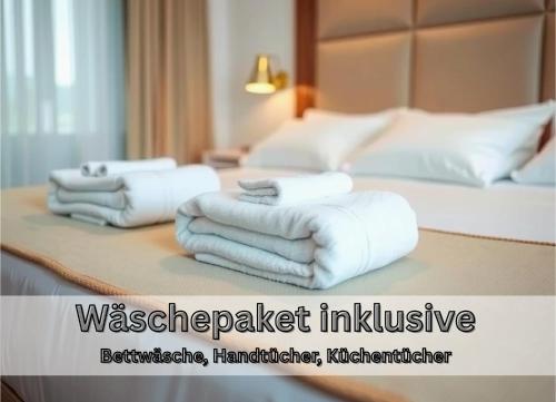 Ein Stapel Handtücher lag auf einem Bett. in der Unterkunft "Nemo" Papenburg ebenerdig rollstuhlgerecht 83 qm Neubau EBK 2 Schlafzimmer 4 Personen Free Wifi in Papenburg