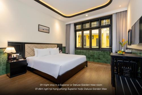 a bedroom with a white bed and a large window at Lantern Boutique Hoi An in Hoi An