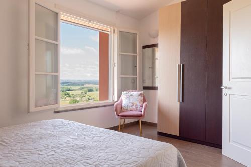 a bedroom with a bed and a chair and a window at Appartamento Il Nespolo in Pontedera