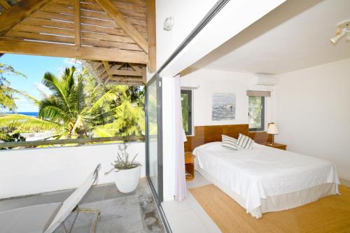 a bedroom with a bed and a view of the ocean at Peter's Beach House in Poste Lafayette