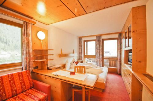 a living room with a couch and a table in a room at Hotel Garni Hainbacherhof in Sölden