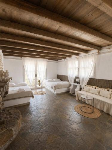 a large room with two beds and two tables at Paros Poolside Cozy Nests - Summer & Salty Getaways in Kalami