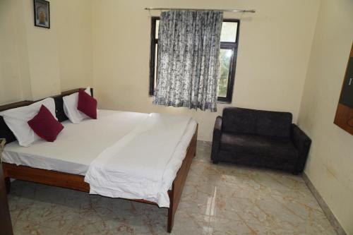 a bedroom with a bed and a chair and a window at Hotel Moon Mahal in Jaipur