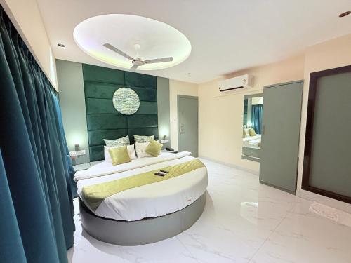 a bedroom with a large bed and a ceiling at Hotel Adkar Residency Borivali West in Mumbai
