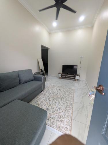 a living room with a couch and a flat screen tv at Shareen Homestay Morib in Banting