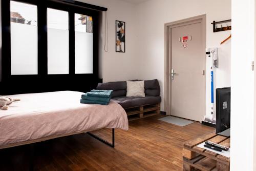 a living room with a bed and a couch at Studio Cocoon in Colombey-les-Belles