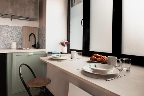 a kitchen with a table with plates of food on it at Studio Cocoon in Colombey-les-Belles