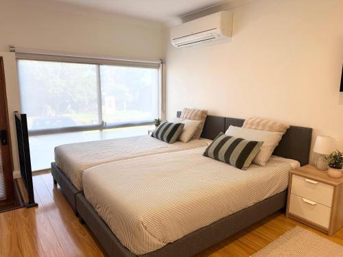 a large bed in a room with a large window at Studio with private kitchenette and bathroom in Leumeah