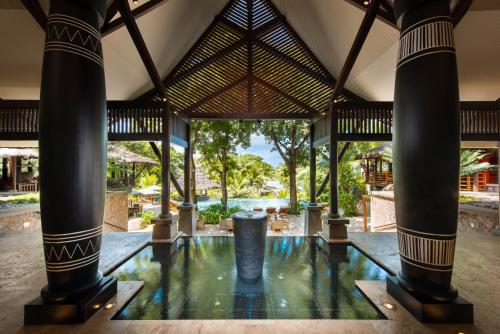 une piscine au milieu d'un bâtiment avec colonnes dans l'établissement Constance Lemuria, à Grand'Anse