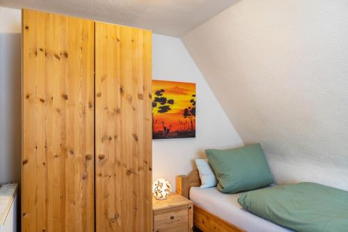 a bedroom with a bed and a wooden cabinet at Ferienhaus Eisfelder Blick in Eisfeld