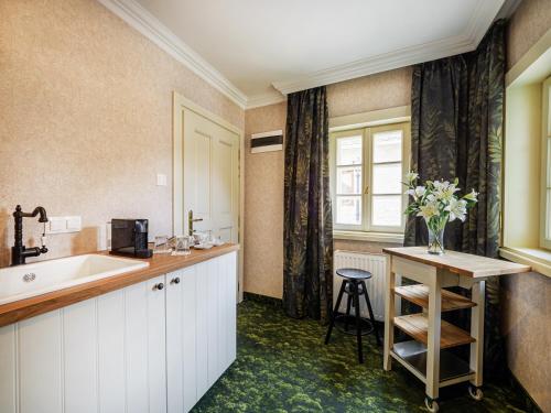 a bathroom with a tub and a sink and a table at Platán Utca - Platán Tata in Tata