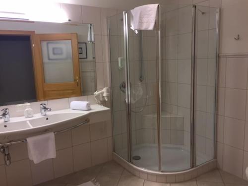 y baño con ducha y lavamanos. en Landhotel Forsthof en Sierning