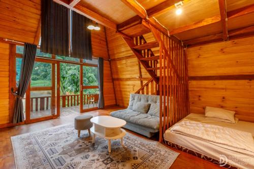 a room with a bed and a couch in a cabin at Villa Ira Dieng in Diyeng