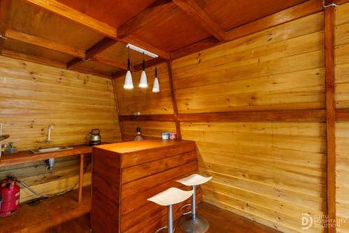 a room with two stools in a wooden room at Villa Ira Dieng in Diyeng