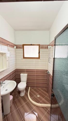 a bathroom with a toilet and a sink and a shower at Illyrian Hotel in Lezhë