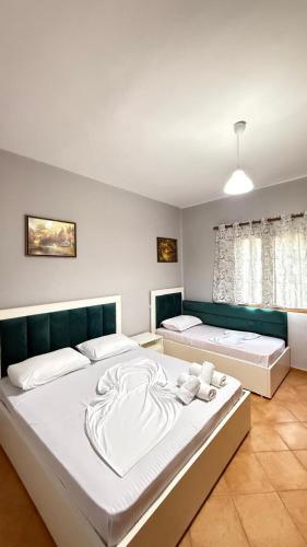 a bedroom with two beds with white sheets at Illyrian Hotel in Lezhë
