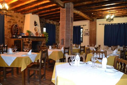 a restaurant with tables and chairs with white table cloth at Rincón del Abade in Encinasola