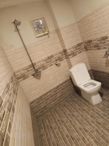 a bathroom with a white toilet in a room at Fivee Hotel Model Town Multan in Multan