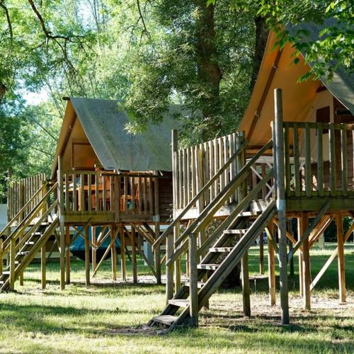 a group of wooden play structures in a park at Camping Onlycamp Le Sabot in Azay-le-Rideau