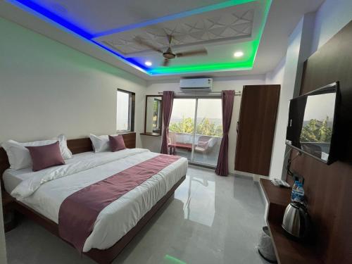 a bedroom with a large bed and a tv in it at Hotel Green lotus villa mahabaleshwar in Mahabaleshwar