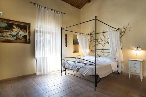 a bedroom with a canopy bed and a window at La Locanda degli Amici in Santa Teresa di Riva