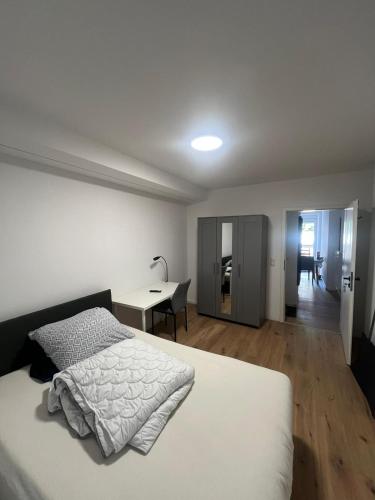 a white bedroom with a bed and a desk at Ethical Choice Residence in Kaiserslautern