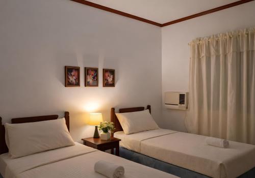 a hotel room with two beds and a window at Kyleville Resort by Hiverooms in Dalaguete