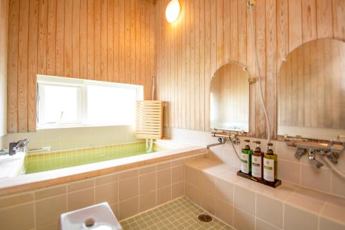 a bathroom with a tub and a sink and a toilet at べっどぷらす in Wakkanai