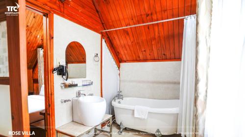 a bathroom with a tub and a toilet and a sink at TTC Dreamy Hill Resort - Unlimited Access to TTC World - Thung Lung Tinh Yeu in Da Lat