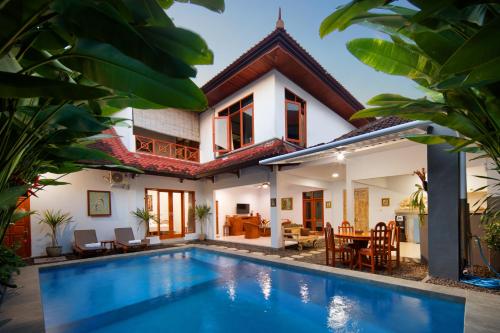 a villa with a swimming pool in front of a house at Hildiman Villa Kuta - Two Bedroom Private pool in Kuta