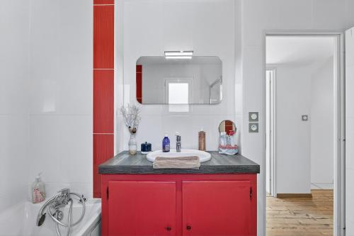 a bathroom with a red cabinet with a sink at Location Vacances Chorges in Chorges