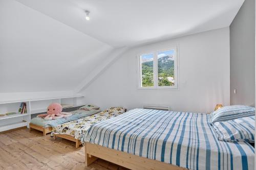 a white bedroom with a bed and a window at Location Vacances Chorges in Chorges