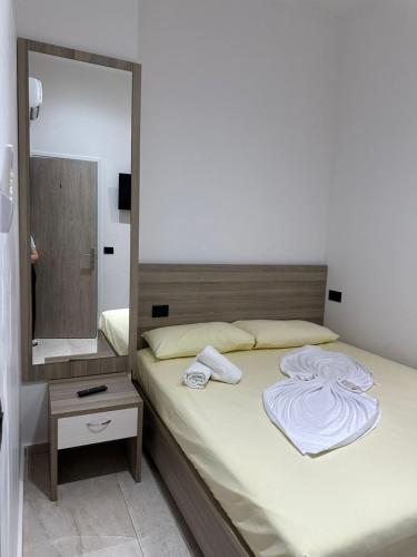 a bedroom with a bed with a large mirror at Central Boutique Hostel in Sarandë