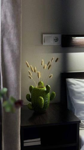 a green vase sitting on a table in a bedroom at Hotel Dolynskiy in Lviv