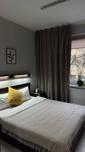 a bedroom with a bed with a yellow pillow on it at Hotel Dolynskiy in Lviv