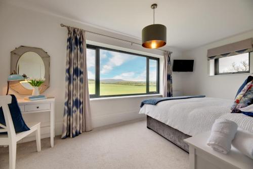 a bedroom with a bed and a window at The Coach House in Alnwick