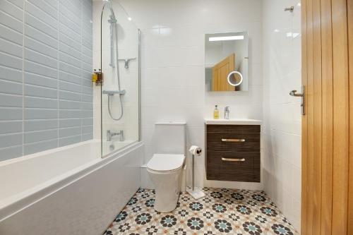 a bathroom with a toilet and a sink and a shower at The Coach House in Alnwick