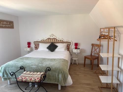 a bedroom with a bed with a green blanket at Le Fournil in Fiennes