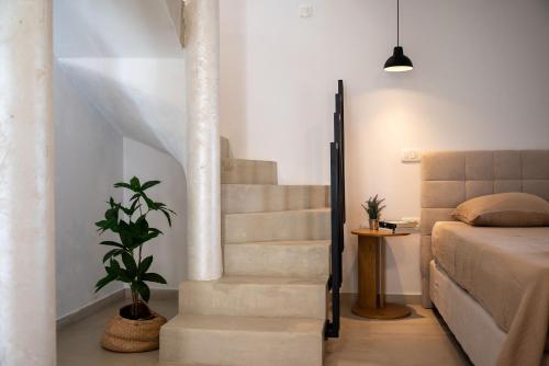 a staircase in a bedroom with a bed and a plant at Fonte Perila House in Funtana